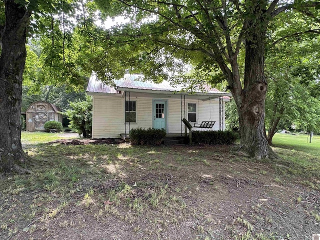 67 Beshear Ln, Princeton, KY 42445 - view of front facade featuring covered porch, a shed, and a metal roof