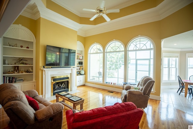 129 Wayne Cir, New Concord, KY 42076 - living area with a ceiling fan, a tile fireplace, ornamental molding, wood finished floors, and built in features