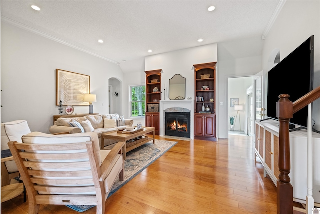 130 Camden Way, Paducah, KY 42001 - living room featuring crown molding, arched walkways, recessed lighting, a fireplace with flush hearth, and light wood-type flooring
