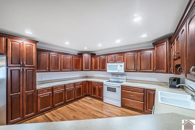 1530 Holt Rd, Paducah, KY 42001 - kitchen with white appliances, light wood-style flooring, light countertops, recessed lighting, and dark brown cabinets