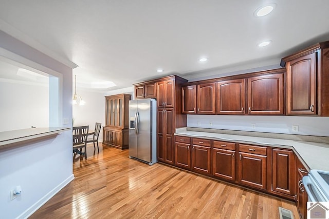 1530 Holt Rd, Paducah, KY 42001 - kitchen featuring stainless steel fridge with ice dispenser, stove, light wood-style flooring, light countertops, and ornamental molding