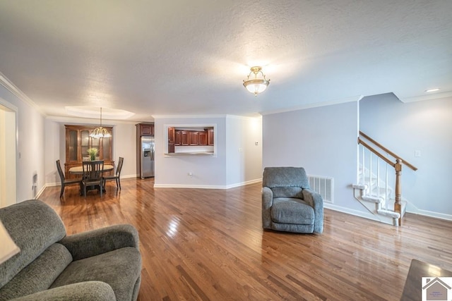 1530 Holt Rd, Paducah, KY 42001 - living room with wood finished floors, stairs, crown molding, a textured ceiling, and a chandelier