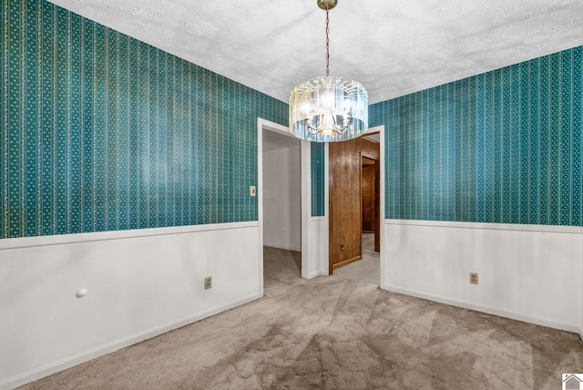 301 Tremont Dr, Hopkinsville, KY 42240 - carpeted spare room featuring wallpapered walls, a textured ceiling, a chandelier, and a wainscoted wall