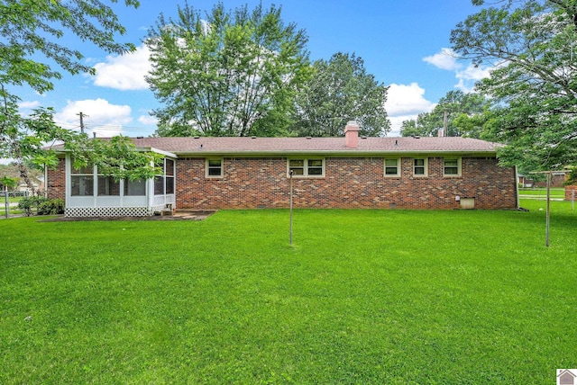 301 Tremont Dr, Hopkinsville, KY 42240 - rear view of house with a sunroom, brick siding, a yard, and a chimney