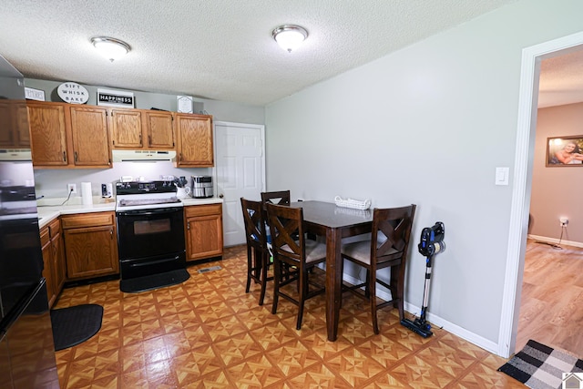 1040 Weda Cir, Mayfield, KY 42066 - kitchen featuring black range with electric stovetop, under cabinet range hood, light countertops, a textured ceiling, and brown cabinets