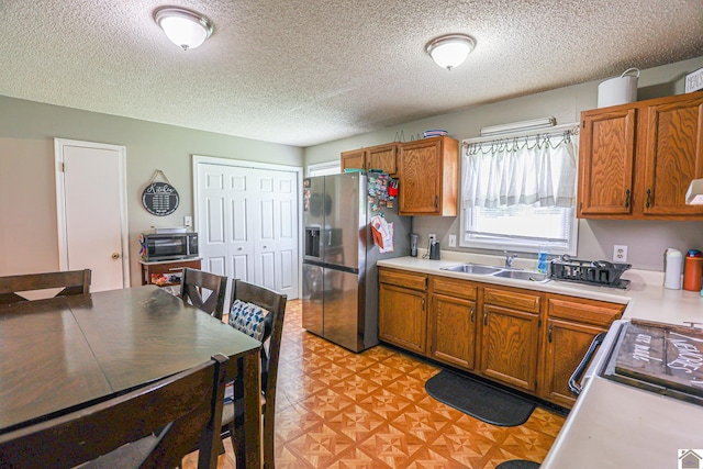 1040 Weda Cir, Mayfield, KY 42066 - kitchen featuring stainless steel fridge, light countertops, brown cabinets, and a textured ceiling