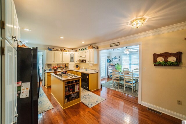 1201 Winslow Way, Paducah, KY 42001 - kitchen featuring black appliances, a kitchen island, a ceiling fan, ornamental molding, and dark wood-style flooring