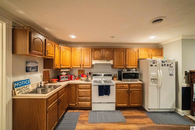 1201 Winslow Way, Paducah, KY 42001 - kitchen with white appliances, under cabinet range hood, crown molding, light countertops, and dark wood-style flooring