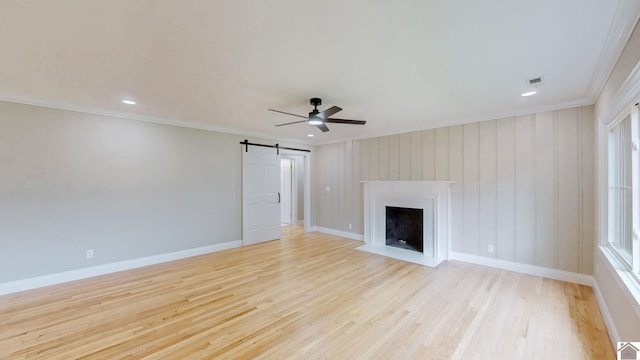 700 S 16th, Murray, KY 42071 - unfurnished living room featuring ornamental molding, light wood-type flooring, a ceiling fan, a fireplace with flush hearth, and a barn door