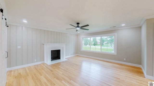 700 S 16th, Murray, KY 42071 - unfurnished living room with light wood-type flooring, crown molding, a barn door, ceiling fan, and a fireplace with flush hearth