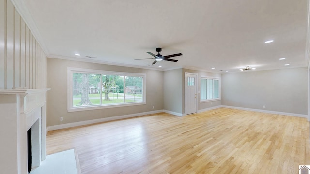 700 S 16th, Murray, KY 42071 - unfurnished living room with plenty of natural light, ornamental molding, light wood-type flooring, a ceiling fan, and a fireplace with flush hearth