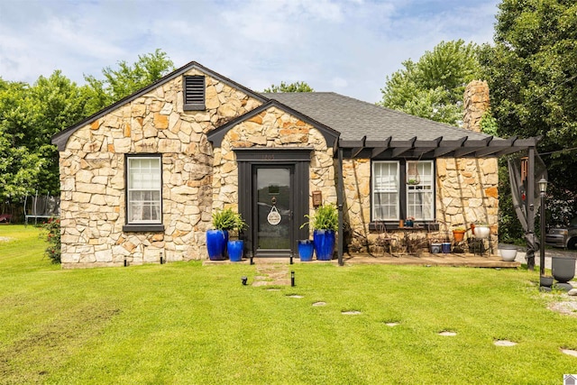 1205 Wilford St, Mayfield, KY 42066 - view of front facade with stone siding, a trampoline, a front yard, a chimney, and a shingled roof