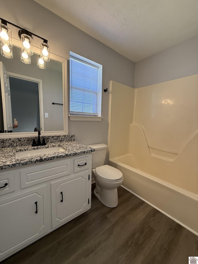 2042 Carneal Ln, Oak Grove, KY 42262 - full bathroom with wood finished floors, vanity, a textured ceiling, and bathing tub / shower combination