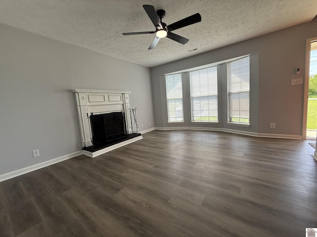 2042 Carneal Ln, Oak Grove, KY 42262 - unfurnished living room with healthy amount of natural light, a textured ceiling, a ceiling fan, and dark wood-type flooring