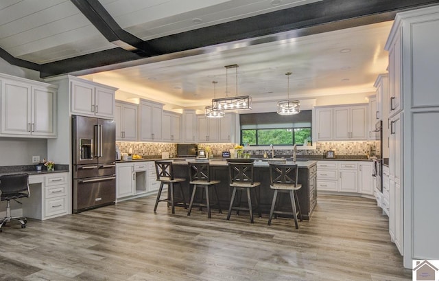 1 Logan Trl, Murray, KY 42071 - kitchen with high end refrigerator, dark countertops, a kitchen bar, backsplash, and beamed ceiling