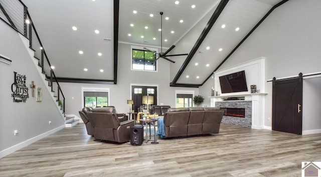 1 Logan Trl, Murray, KY 42071 - living room with high vaulted ceiling, a ceiling fan, plenty of natural light, a stone fireplace, and light wood-style flooring