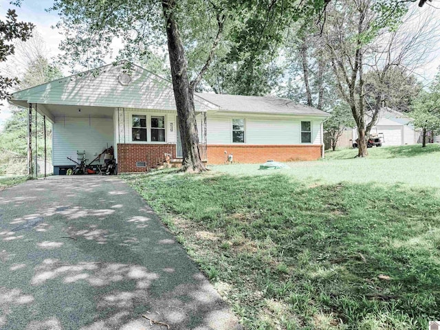 719 Elder St, Calvert City, KY 42029 - view of front of house with asphalt driveway, brick siding, a front yard, and an attached carport