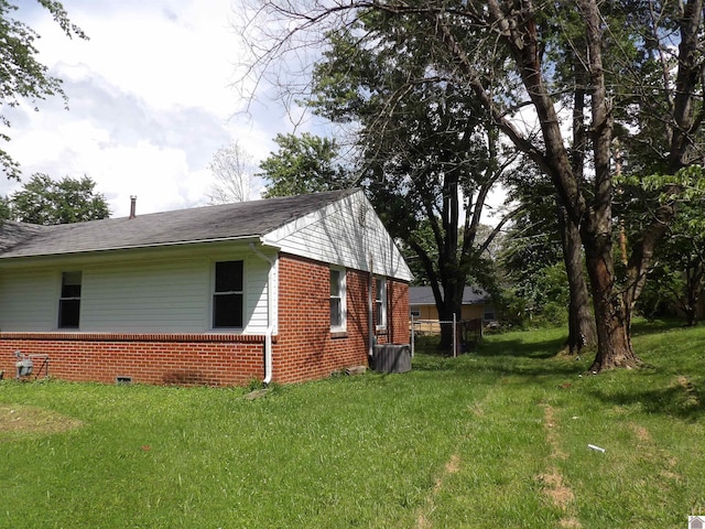 719 Elder St, Calvert City, KY 42029 - view of home's exterior with brick siding, a lawn, and a shingled roof