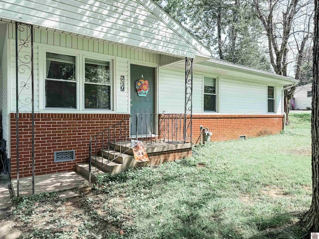 719 Elder St, Calvert City, KY 42029 - property entrance with crawl space, brick siding, and a yard