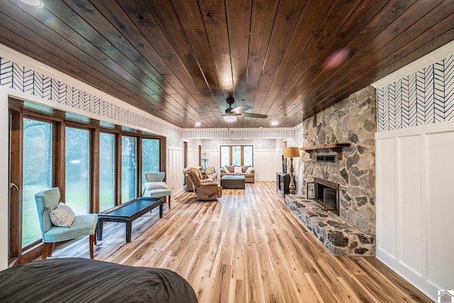 150 Sills Ln, Benton, KY 42025 - living room featuring wooden ceiling, light wood finished floors, a ceiling fan, a stone fireplace, and crown molding