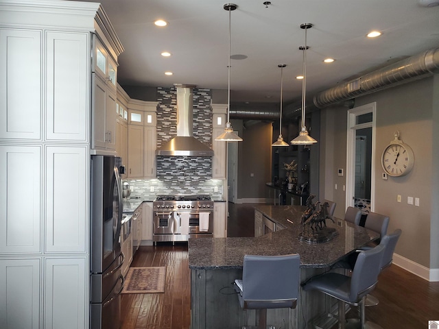117 N 2nd, Paducah, KY 42001 - kitchen featuring appliances with stainless steel finishes, wall chimney exhaust hood, dark wood-style flooring, recessed lighting, and decorative backsplash
