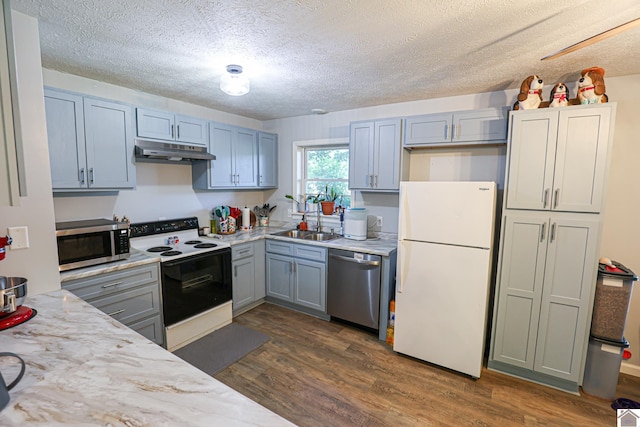 1715 State Route 80 W, Arlington, KY 42021 - kitchen with appliances with stainless steel finishes, under cabinet range hood, a textured ceiling, dark wood-style flooring, and light stone countertops