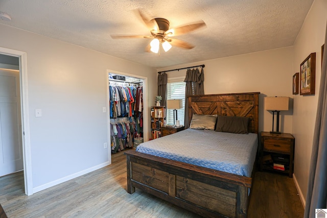 1715 State Route 80 W, Arlington, KY 42021 - bedroom with light wood-type flooring, a textured ceiling, a ceiling fan, a closet, and a walk in closet