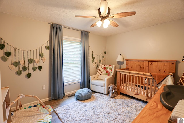 1715 State Route 80 W, Arlington, KY 42021 - bedroom with wood finished floors, a textured ceiling, a nursery area, and a ceiling fan