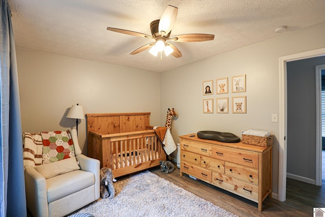 1715 State Route 80 W, Arlington, KY 42021 - bedroom featuring wood finished floors, a textured ceiling, ceiling fan, and a nursery area
