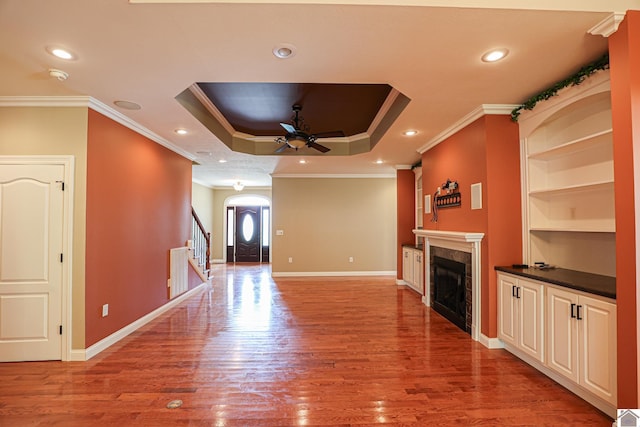 329 Royal Park Dr, Calvert City, KY 42029 - unfurnished living room with a tiled fireplace, a ceiling fan, light wood finished floors, arched walkways, and ornamental molding