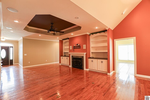 329 Royal Park Dr, Calvert City, KY 42029 - unfurnished living room featuring crown molding, ceiling fan, a fireplace, light wood finished floors, and built in shelves