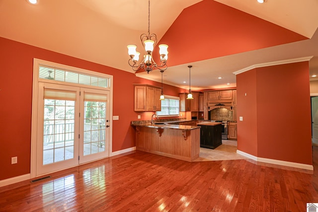 329 Royal Park Dr, Calvert City, KY 42029 - kitchen featuring a peninsula, lofted ceiling, a kitchen bar, light wood-type flooring, and hanging light fixtures