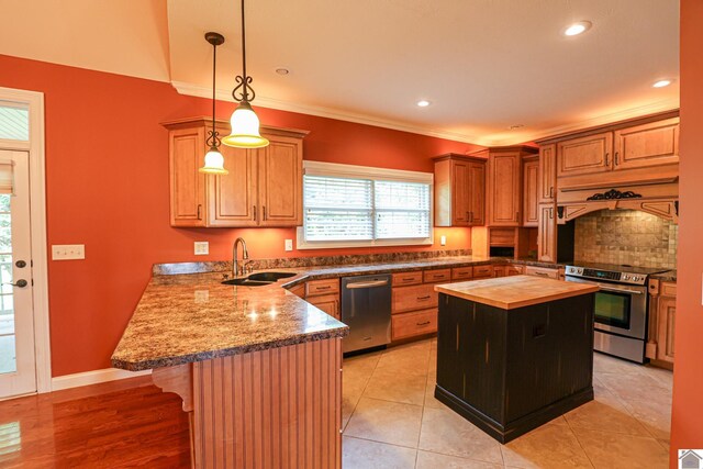 329 Royal Park Dr, Calvert City, KY 42029 - kitchen with stainless steel appliances, butcher block countertops, a peninsula, backsplash, and a kitchen breakfast bar