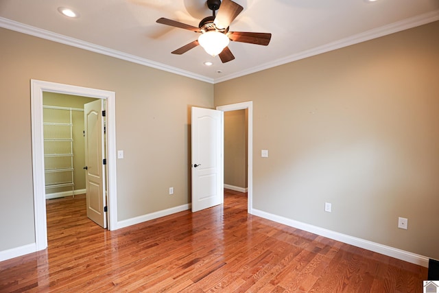 329 Royal Park Dr, Calvert City, KY 42029 - unfurnished bedroom with a walk in closet, ornamental molding, light wood-type flooring, recessed lighting, and a closet