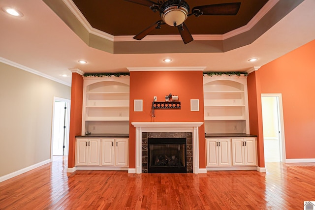329 Royal Park Dr, Calvert City, KY 42029 - unfurnished living room featuring ceiling fan, a tile fireplace, ornamental molding, light wood-style flooring, and built in features