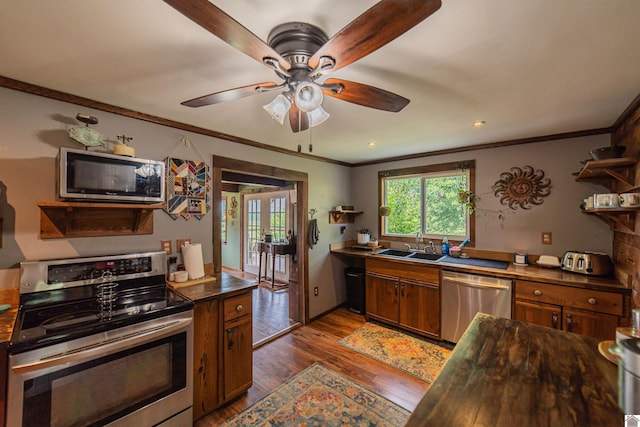 353 Creswell Rd, Princeton, KY 42445 - kitchen featuring stainless steel appliances, ornamental molding, wood finished floors, a ceiling fan, and brown cabinets