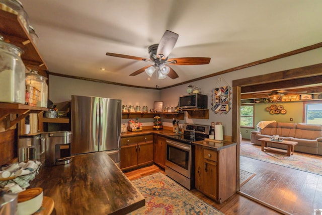 353 Creswell Rd, Princeton, KY 42445 - kitchen with appliances with stainless steel finishes, brown cabinets, dark countertops, crown molding, and light wood-style flooring