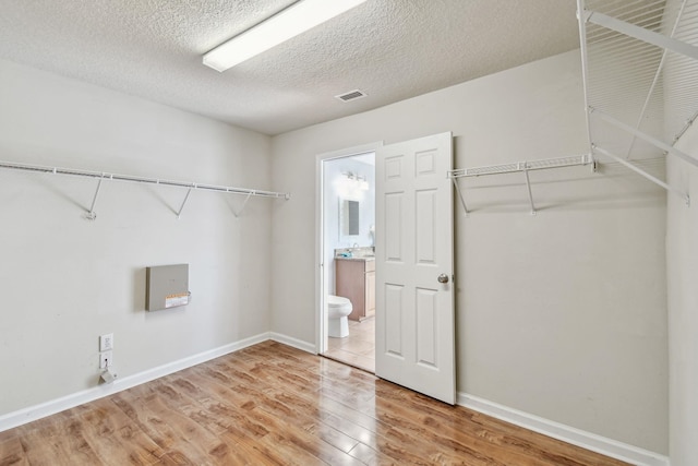 laundry room featuring hardwood / wood-style flooring and a textured ceiling