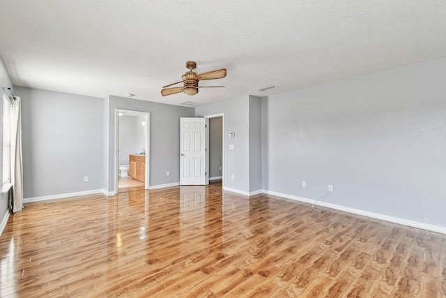 interior space featuring ceiling fan, light hardwood / wood-style flooring, a textured ceiling, and ensuite bathroom