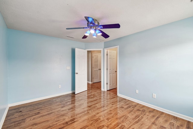 spare room with hardwood / wood-style floors, a textured ceiling, and ceiling fan