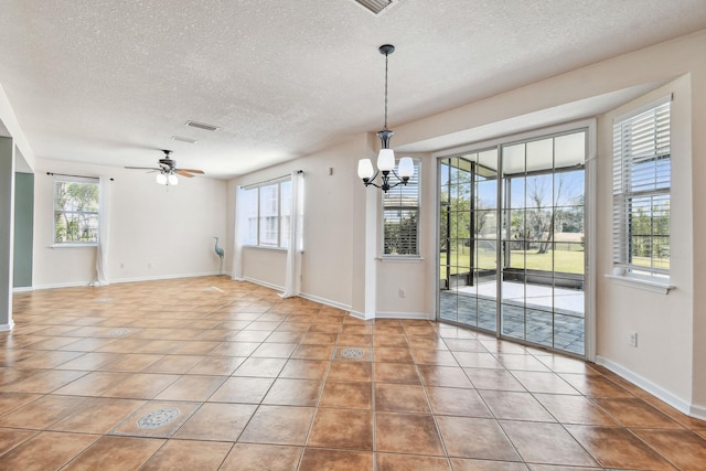 empty room featuring tile patterned flooring, ceiling fan with notable chandelier, and a textured ceiling