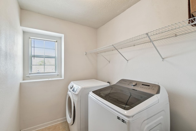 washroom with independent washer and dryer and a textured ceiling