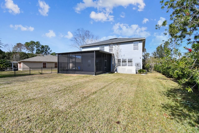 rear view of property with a yard and a sunroom