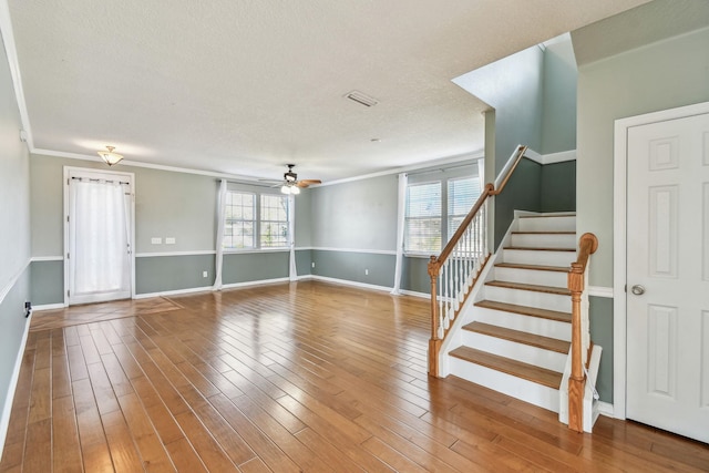 unfurnished living room with hardwood / wood-style floors, crown molding, a textured ceiling, and ceiling fan