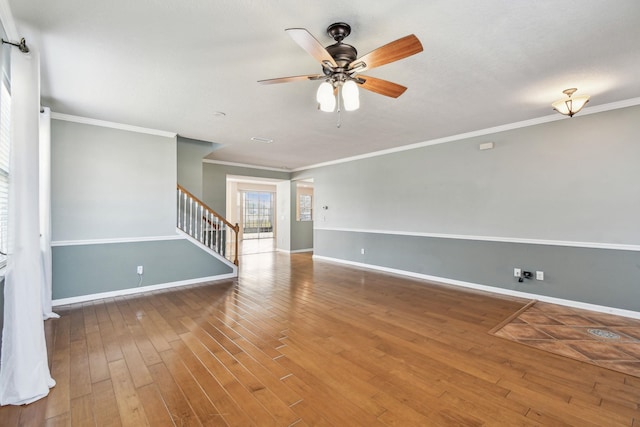 empty room with wood-type flooring, ornamental molding, and ceiling fan