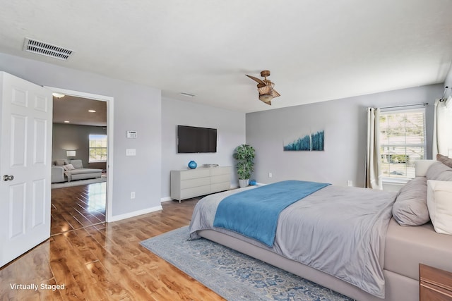 bedroom with hardwood / wood-style floors and multiple windows