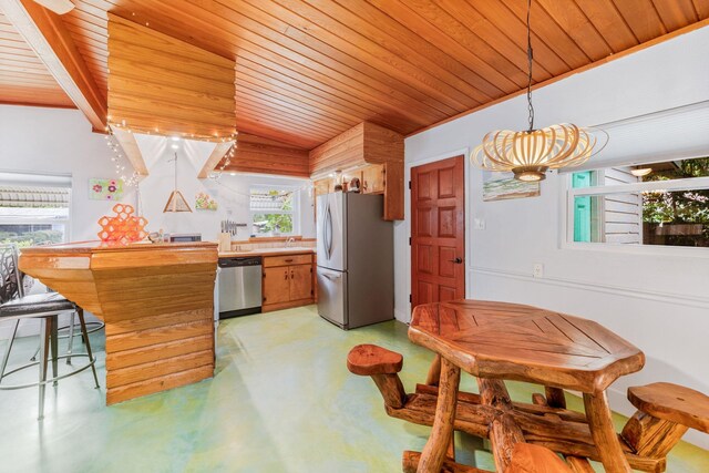 kitchen with hanging light fixtures, appliances with stainless steel finishes, plenty of natural light, and wooden ceiling