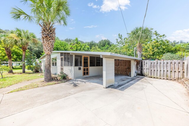 view of front of home featuring a sunroom and a carport