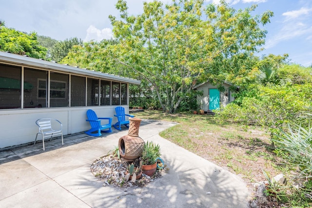 view of patio / terrace with a sunroom and a storage unit