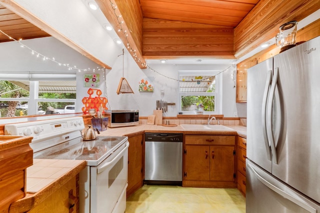 kitchen featuring tile counters, sink, stainless steel appliances, lofted ceiling, and wood ceiling